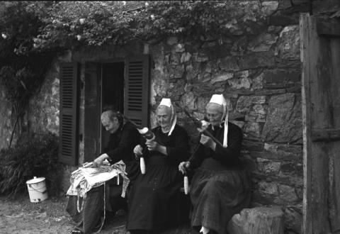 Plomodiern. Fileuses assises devant une maison (1930-1940) (fonds Godineau) (14 Fi 549)